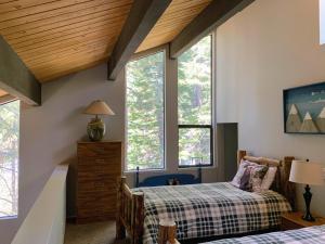 two beds in a room with windows at Woodsy retreat near Northstar & lake in Kings Beach