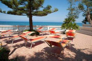 un grupo de sillas y mesas en la playa en Case Vacanze De Simone zona Pozzillo en Castellabate