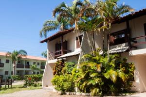 a building with palm trees in front of it at Residencial Villa Luana in Garopaba