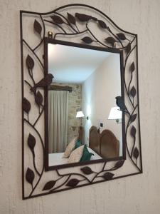 um espelho com uma moldura de madeira numa parede em hostal Decerca Prádena em Prádena