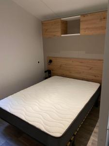 Ce lit se trouve dans un dortoir doté d'un matelas blanc. dans l'établissement MOBIL-HOME NEUF 2021 3CH 34 M2, à Saint-Cyprien