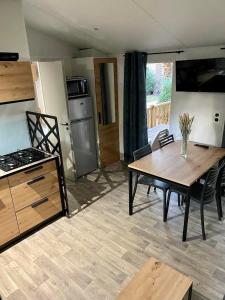 uma sala de estar com uma mesa e uma cozinha em MOBIL-HOME NEUF 2021 3CH 34 M2 em Saint-Cyprien