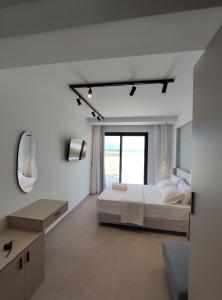 a white bedroom with a bed and a mirror at Onar in Sarti in Sarti