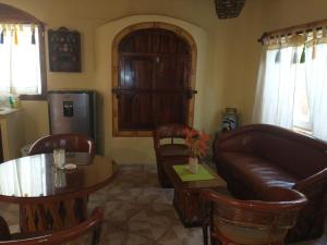sala de estar con sofá de cuero y mesa en Hacienda Jaqueline en Sayulita