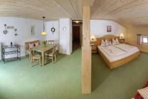 a bedroom with a bed and a table in a room at Holznerhof - Chiemgau Karte in Inzell