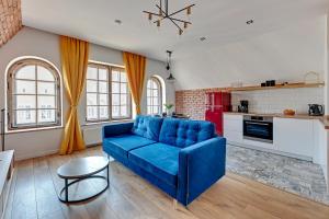 a living room with a blue couch and a kitchen at Pola by Q4Apartments - heart of the Old Town in Gdańsk