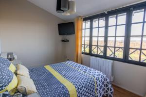 1 dormitorio con 1 cama, TV y ventanas en Maison chaleureuse-Grand jardin-Proche Saumur, en Parnay