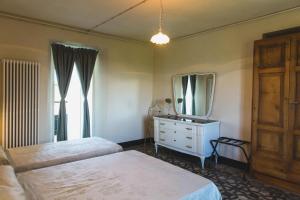 - une chambre avec 2 lits, un miroir et une commode dans l'établissement Casa San Michele - Affittacamere Panoramico con Spa, à Parodi Ligure