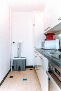 cocina con armarios blancos y encimera en Messe Apartments in the center of basel en Basilea