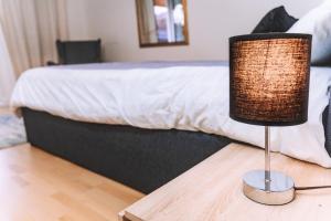 a lamp sitting on a table next to a bed at Messe Apartments in the center of basel in Basel