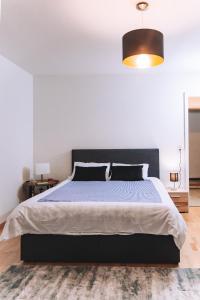 a bedroom with a large bed with a black headboard at Messe Apartments in the center of basel in Basel