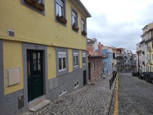 une rue pavée dans une ville avec des bâtiments dans l'établissement Apartamento acolhedor no coração de Lisboa, à Lisbonne
