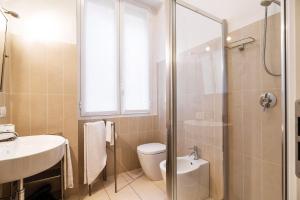 een badkamer met een douche, een toilet en een wastafel bij Contempora Apartments - Cavallotti 13 - B24 in Milaan