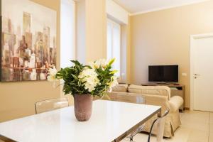 een woonkamer met een vaas met bloemen op een tafel bij Contempora Apartments - Cavallotti 13 - B24 in Milaan