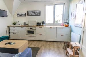 a kitchen with white cabinets and a table at Bons Baisers du Touquet - Le Parc in Cucq