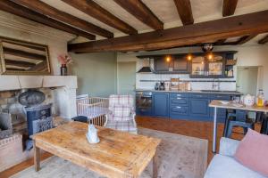 Il comprend un salon avec une table et une cuisine. dans l'établissement Maison chaleureuse-Grand jardin-Proche Saumur, à Parnay
