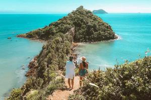 two people standing on a hill looking at the ocean at Hostel Blue House Búzios in Búzios