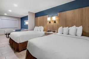 una habitación de hotel con 2 camas y una pantalla en Best Western PLUS Edinburg Inn & Suites, en Edinburg