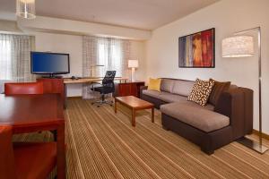 a living room with a couch and a desk at Sonesta ES Suites Charlottesville University in Charlottesville