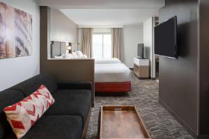 a hotel room with a bed and a couch at Sonesta Select Nashville Airport Suites in Nashville
