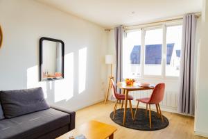 a living room with a table and a couch at Bons Baisers du Touquet - Le Parc in Cucq