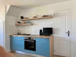 a kitchen with a blue stove and a microwave at Bons Baisers du Touquet - Le Parc in Cucq