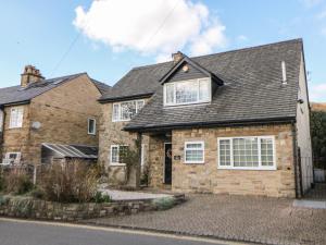 a brick house with a gray roof at Lower Lane House in Chinley