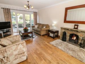 een woonkamer met een bank en een open haard bij Lower Lane House in Chinley