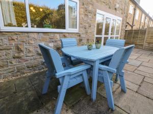 une table bleue et des chaises sur une terrasse dans l'établissement Lower Lane House, à Chinley