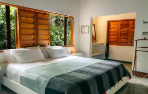 um quarto com uma cama e uma grande janela em Finca Quebradahonda em La Vega