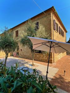 a white umbrella sitting in front of a building at Podere al Fico B&B in Collemezzano