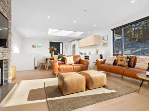 a living room with leather furniture and a living room with a fireplace at Woods Villa Tui in Queenstown
