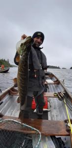 a man holding a large fish in a boat at Ryan's River Lodge B&B in Cong