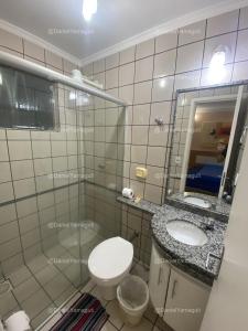 uma casa de banho com um WC, um lavatório e um espelho. em DiRoma Fiori Caldas Novas - YMT - 030 em Caldas Novas