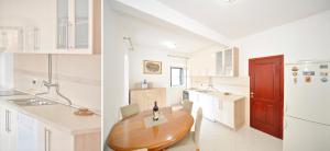 a kitchen with a wooden table and a refrigerator at Sofija Apartment in Kotor +32 photos