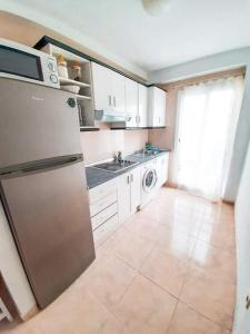 a kitchen with a refrigerator and a sink at Tabaiba apartment in Corralejo +13 photos