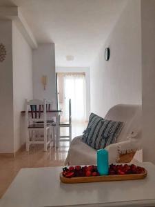 a living room with a bed and a table with fruit on a tray at Tabaiba apartment in Corralejo