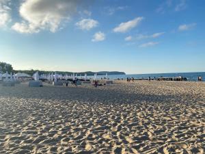 a sandy beach with people walking on the beach at Praia Apartments - 200 m do Plaży Apartament z balkonem i widokiem in Sopot +12 photos