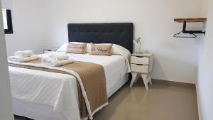 a bedroom with a large bed with a black headboard at Patagonia Apart Dpto 3 in Paraná