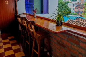 a bar with two wooden chairs in front of a window at Havana Dance School & Hostel in Cali
