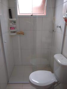 a bathroom with a shower with a toilet and a window at Casa em Villagio em Boracéia próximo a praia. in Bertioga