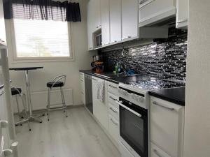 a kitchen with a sink and a stove top oven at M Apartments Tesomankuja in Tampere