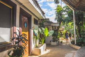 Pura Vida Hostel في تاماريندو: امرأة تسير في شارع مجاور لمبنى