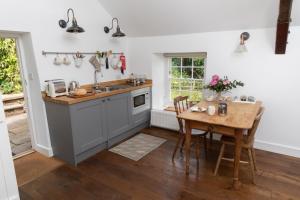 a kitchen with a wooden table and a sink at Loft Apartment nr Bath & Bristol with hot tub in Bristol