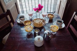 een houten tafel met kommen eten en drinken bij El Hospedaje in Cafayate
