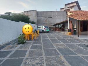 Casa de Praia - Coqueiro - Piauí في لويس كوريا: بوجه مبتسم اصفر جالس في مواقف السيارات