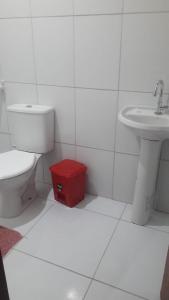 Casa de Praia - Coqueiro - Piauí في لويس كوريا: حمام مع مرحاض ومغسلة مع صندوق احمر