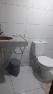 Baño blanco con aseo y lavamanos en Casa de Praia - Coqueiro - Piauí, en Luís Correia