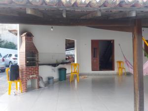 un patio con 2 sillas amarillas y un horno de ladrillo en Casa de Praia - Coqueiro - Piauí, en Luís Correia