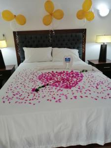 Una cama con flores rosas en ella con globos en Ensenada Resort, en Punta Rucia